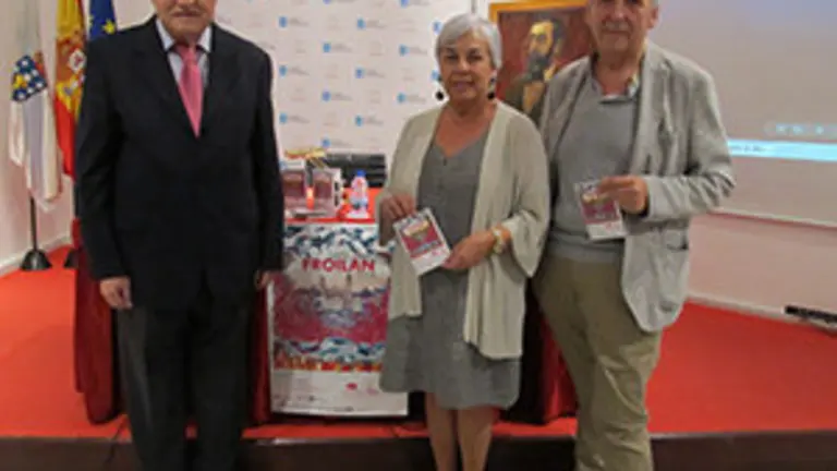 El delegado de la Xunta, José Ramón Ónega, la concejala de Turismo de Lugo, Carmen Basadre, y el periodista Manuel Lombao, con el cartel de las fiestas, antes de comenzar la presentación 