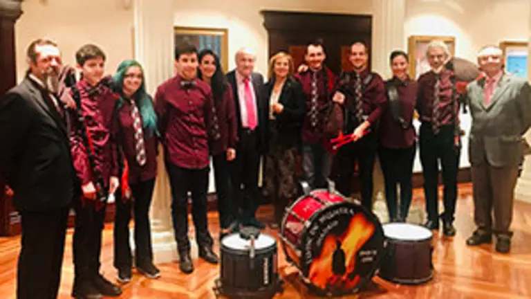 1. Directivos y músicos de Lume de Biqueira posan con el delegado de la Xunta en Madrid, José Ramón Ónega, Pilar Falcón y Carlos de Blas