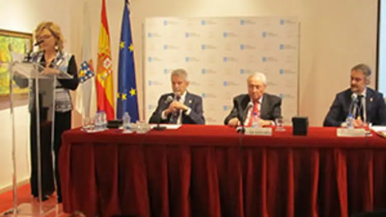 Pilar Falcón, leyendo su discurso de ingreso en la Academia Xacobea.  En la mesa, Jesús Palmou