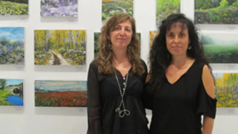 Las pintoras Pilar Quintás y Esperanza Martínez de Salinas ante algunos de los cuadros que exponen en la Casa de Galicia