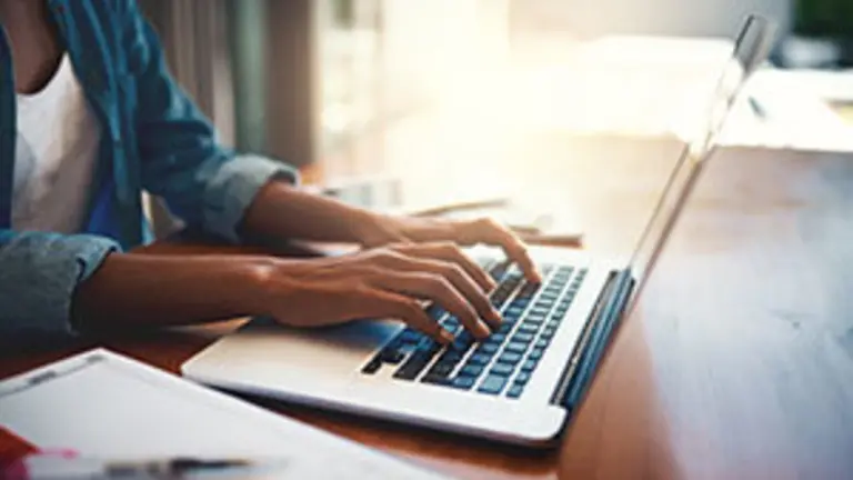 Closeup shot of an unrecognizable woman using a laptop while working from home