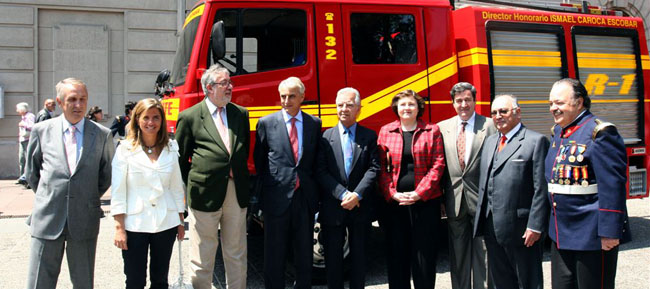 Las autoridades españolas y chilenas posan ante el camión de bomberos donado por la Comunidad de Madrid.