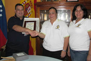 El director de ‘Magazine Español’ recibe una Placa de Reconocimiento en nombre del medio de comunicación, de manos de la presidenta de la Casa Canaria gracitana, Teresa Ysaura Rodríguez Castro.
