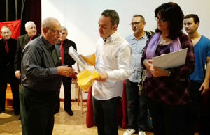 Alberto Valenzuela entrega un libro a Manoel Carrete.