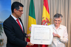 La galardonada muestra el diploma en presencia del embajador.