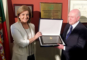 La ministra hace entrega de la Placa de Honor a un representante de la entidad.