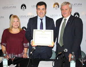 Román Rodríguez, flanqueado por María Amelia Alonso y Emilio Raposo, posa con su distinción de Huésped de Honor.