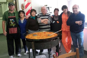 Directivos y cocineros junto a la paella.