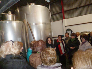 El grupo del Centro Andaluz sigue las explicaciones sobre la bodega.