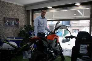 Esteban González, junto a algunas de las motos eléctricas que venden en el local de Enalgreen, en Vigo.