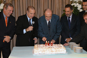 El embajador de España corta la torta aniversario, rodeado de dirigentes de la colectividad.