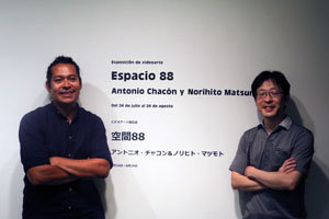 Antonio Chacón –a la izda.– y Norihito Matsumoto posan junto al cartel que anuncia su exposición.