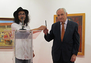 Carlos Santos pasa a José Ramón Ónega el pincel que usó en un gesto en memoria del desastre cultural ocurrido en Brasil.