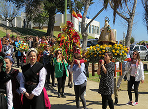 Miembros de la colectividad portan a la virgen en procesión, durante la celebración del Día de Asturias.